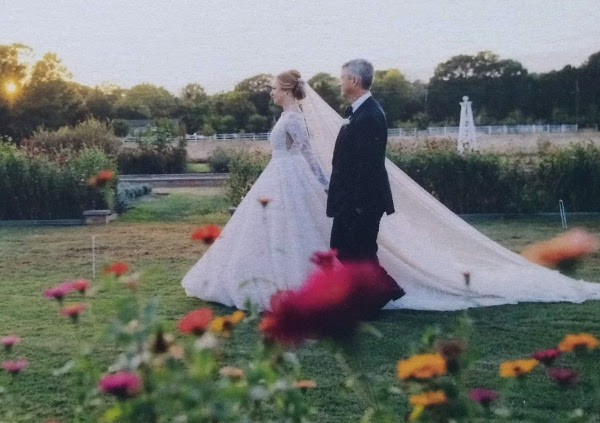 Bride walking through field of flowers